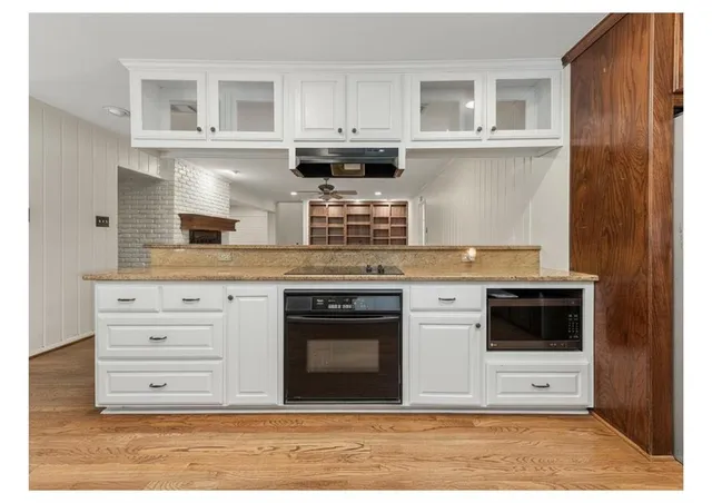 a kitchen with granite countertop a stove cabinets and microwave