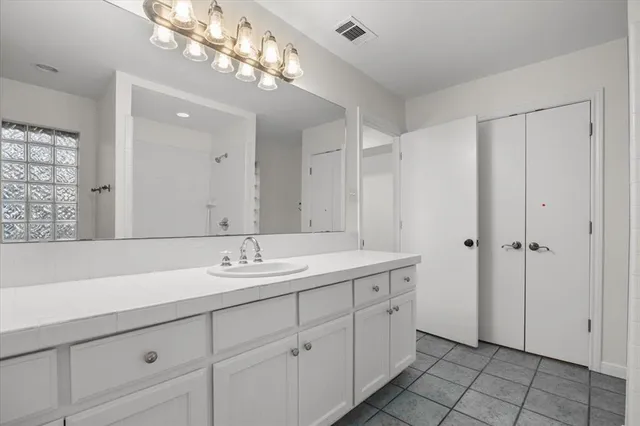 a bathroom with a granite countertop sink a large mirror and a