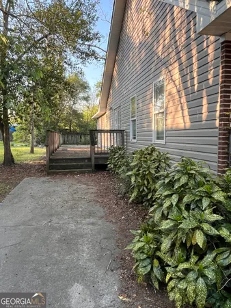 a backyard of a house with a large tree and wooden fence
