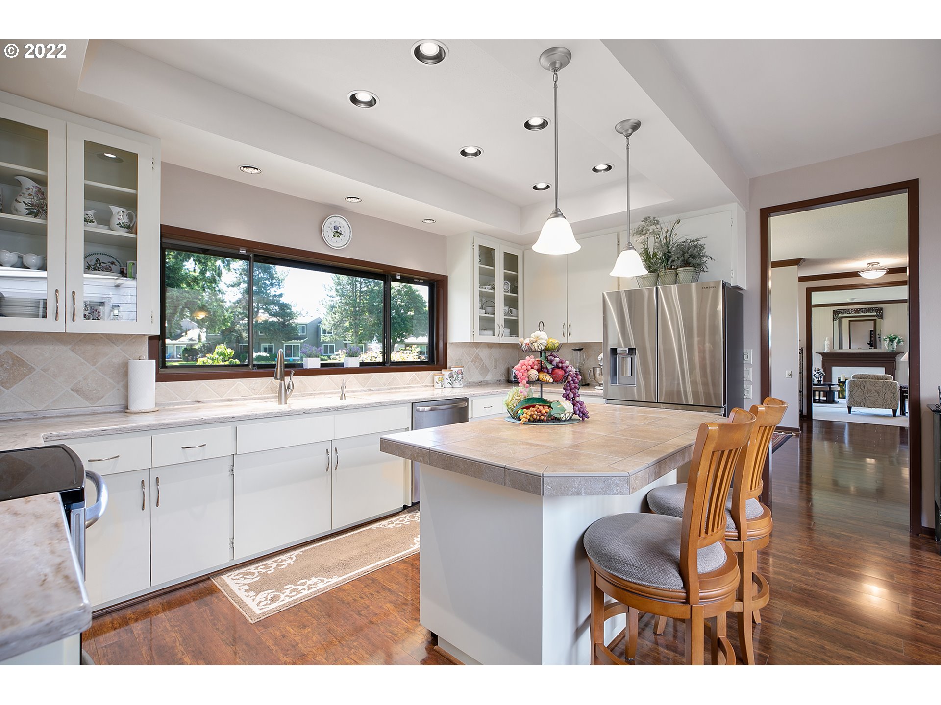 32221 Southwest Boones Bend Road Wilsonville, OR 97070 - Photo 14 of 32 a kitchen with stainless steel appliances kitchen island granite countertop a table chairs sink and wooden cabinets