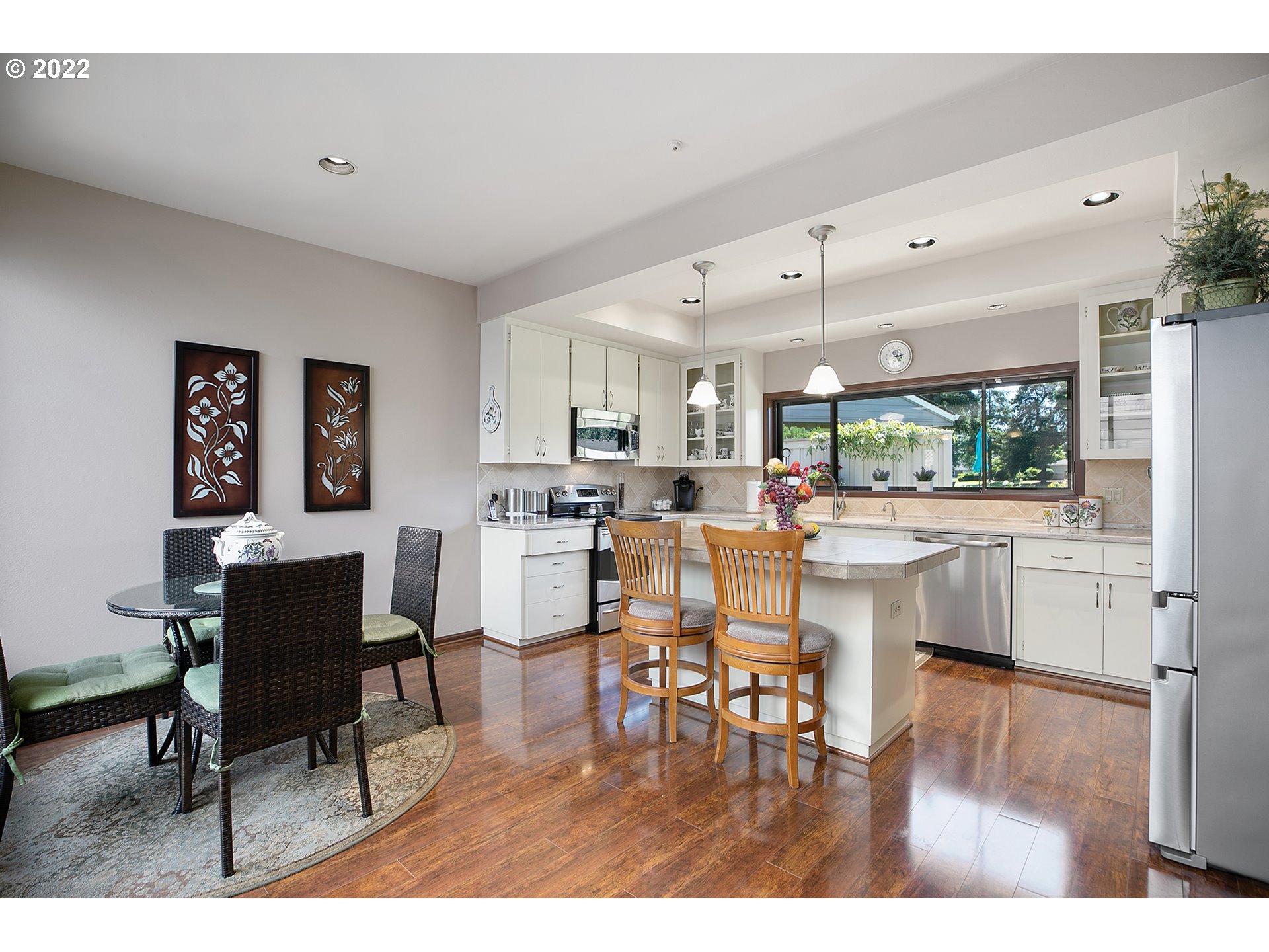 32221 Southwest Boones Bend Road Wilsonville, OR 97070 - Photo 16 of 32 a dining hall with stainless steel appliances kitchen island granite countertop a dining table chairs and a refrigerator