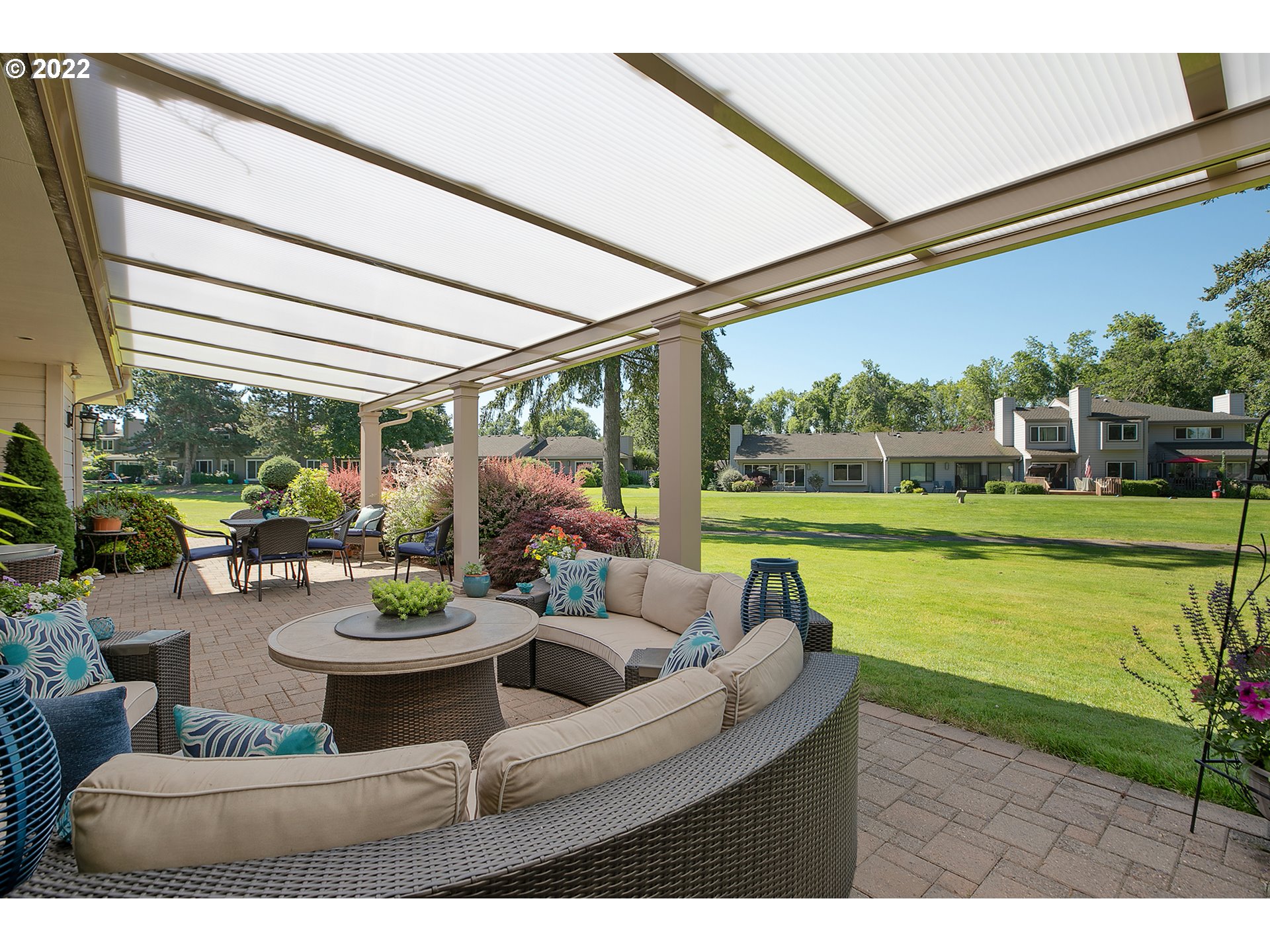 32221 Southwest Boones Bend Road Wilsonville, OR 97070 - Photo 10 of 32 a view of a patio with couches table and chairs potted plants and palm trees