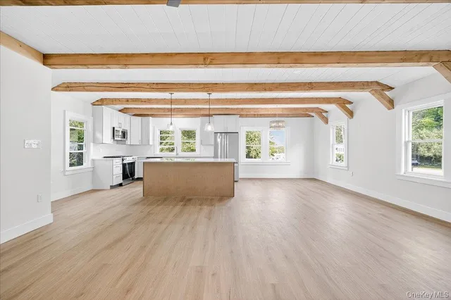 a view of empty room with wooden floor and fireplace