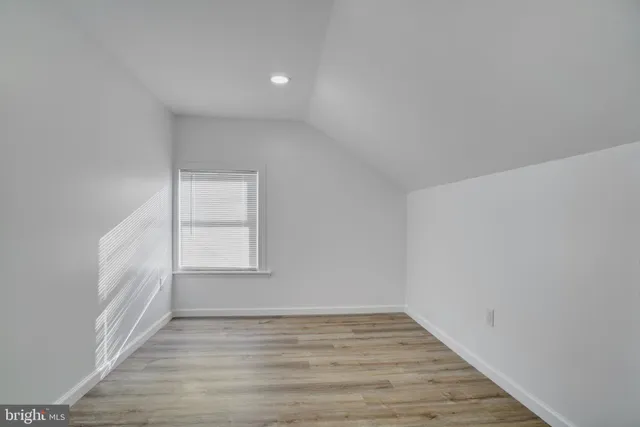 a view of an empty room and wooden floor and a window
