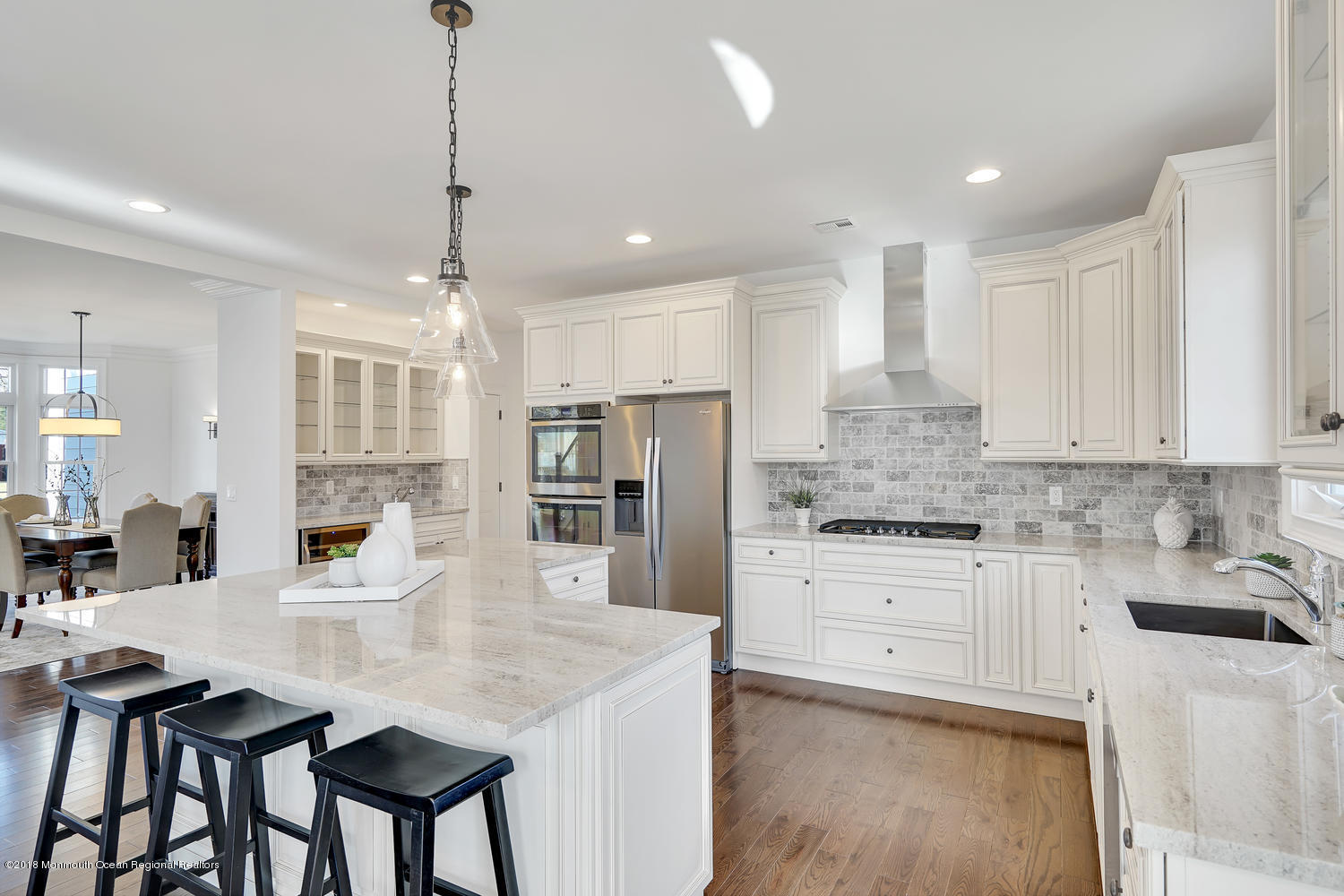 77 Stafford Road Colonia, NJ 07067 - Photo 10 of 17 a kitchen with stainless steel appliances kitchen island granite countertop a stove a sink a dining table and chairs with wooden floor