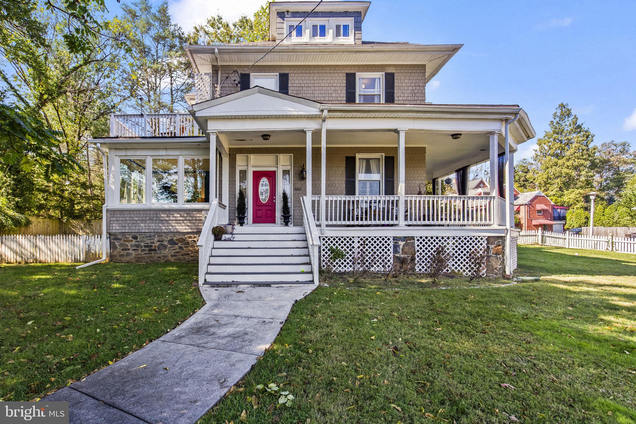 a view of a house with a small yard and a large tree