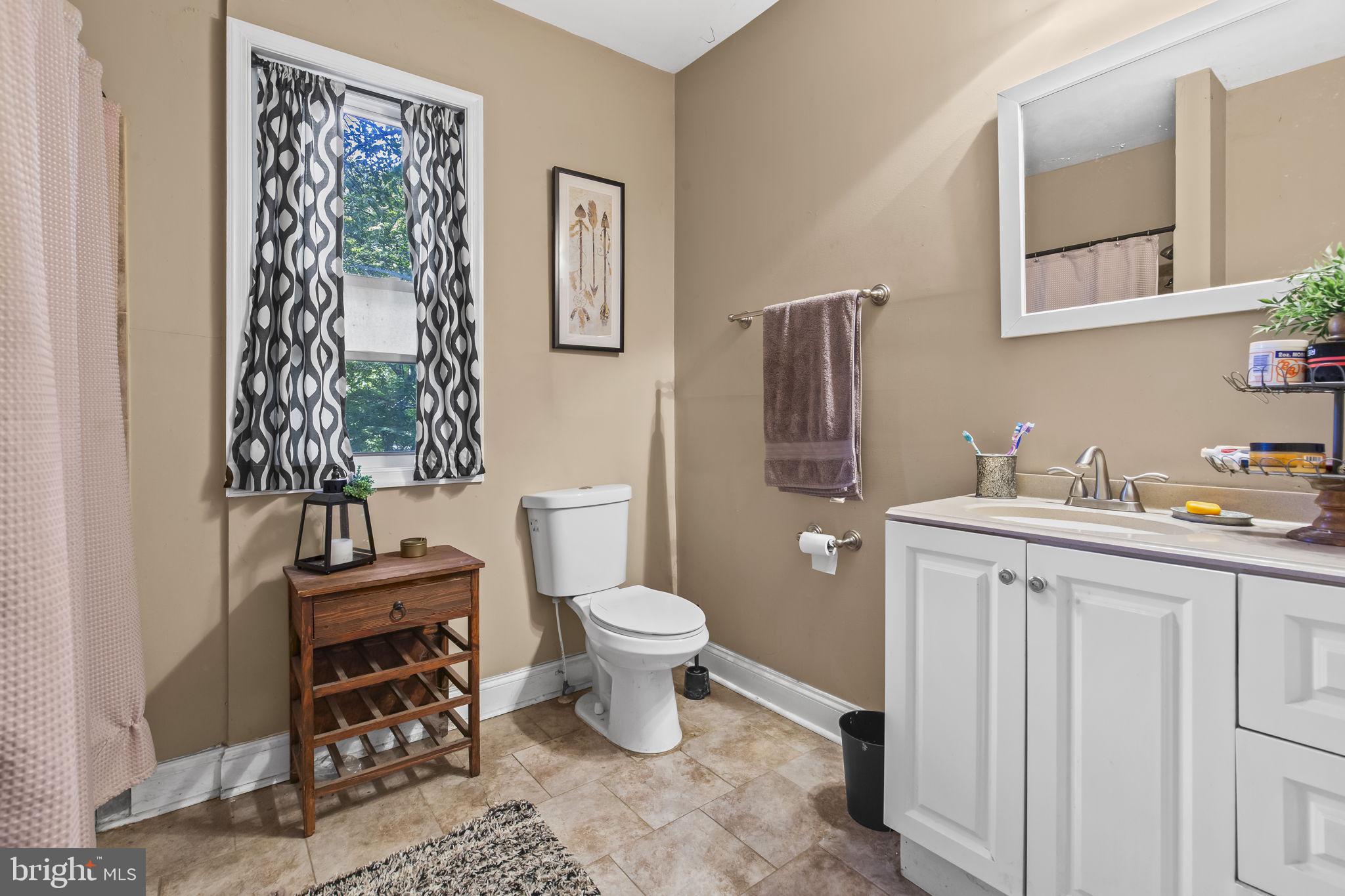 2600 Queen Anne Road Baltimore, MD 21216 - Photo 16 of 29 a bathroom with a toilet a sink and a window