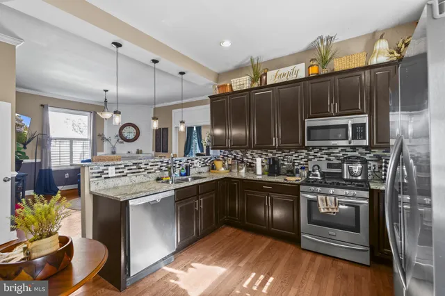 a kitchen with stainless steel appliances kitchen island granite countertop a stove and a sink