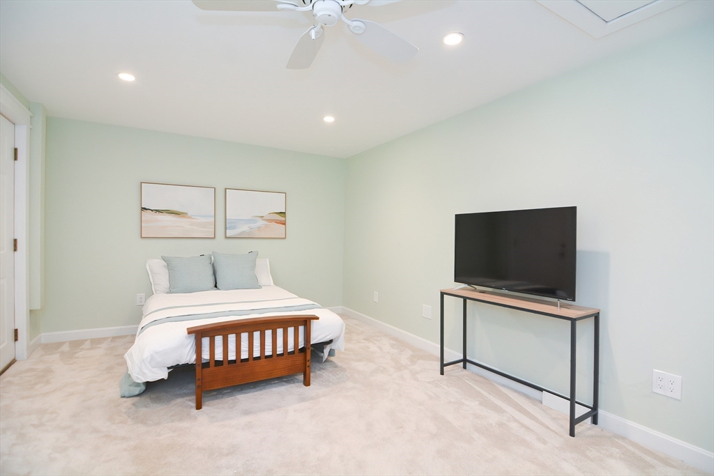 19 Daniels Road Framingham, MA 01701 - Photo 36 of 40 a bedroom with a bed and a flat tv screen on wall