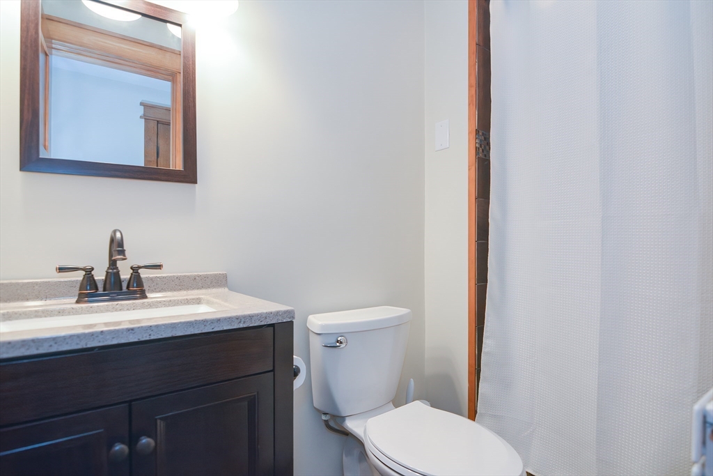 19 Daniels Road Framingham, MA 01701 - Photo 39 of 40 a bathroom with a toilet a sink and mirror