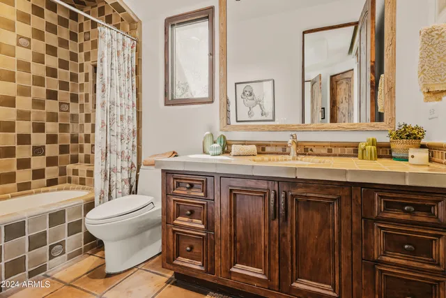 a bathroom with a granite countertop sink a toilet and a shower