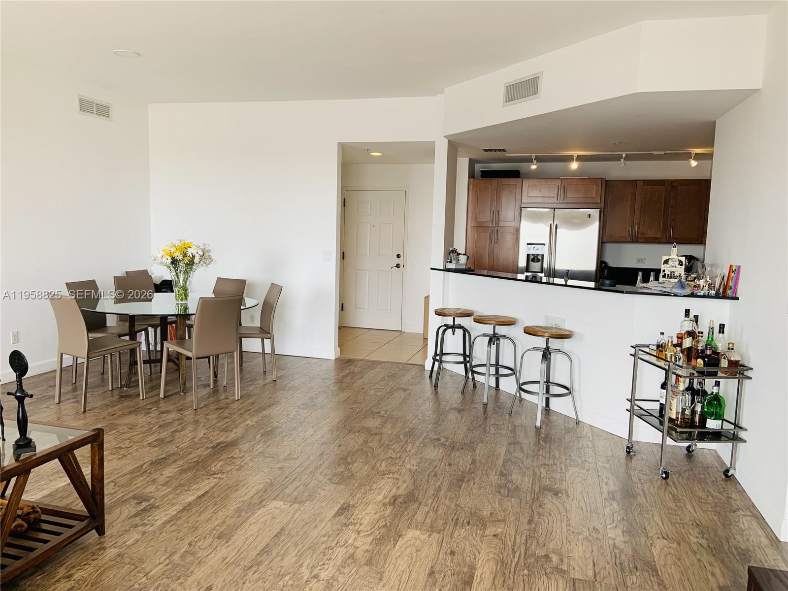 8395 Southwest 73rd Avenue, Unit 704 Miami, FL 33143 - Photo 17 of 47 a living room with furniture and a dining table with wooden floor