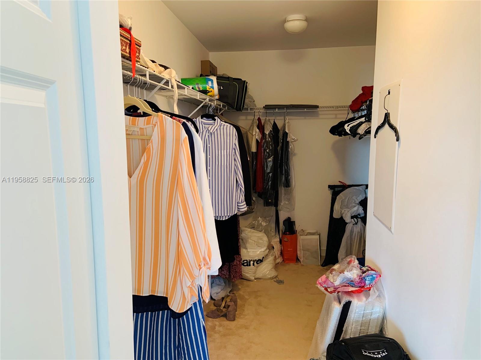 8395 Southwest 73rd Avenue, Unit 704 Miami, FL 33143 - Photo 25 of 47 a view of walk in closet with clothes and shoes