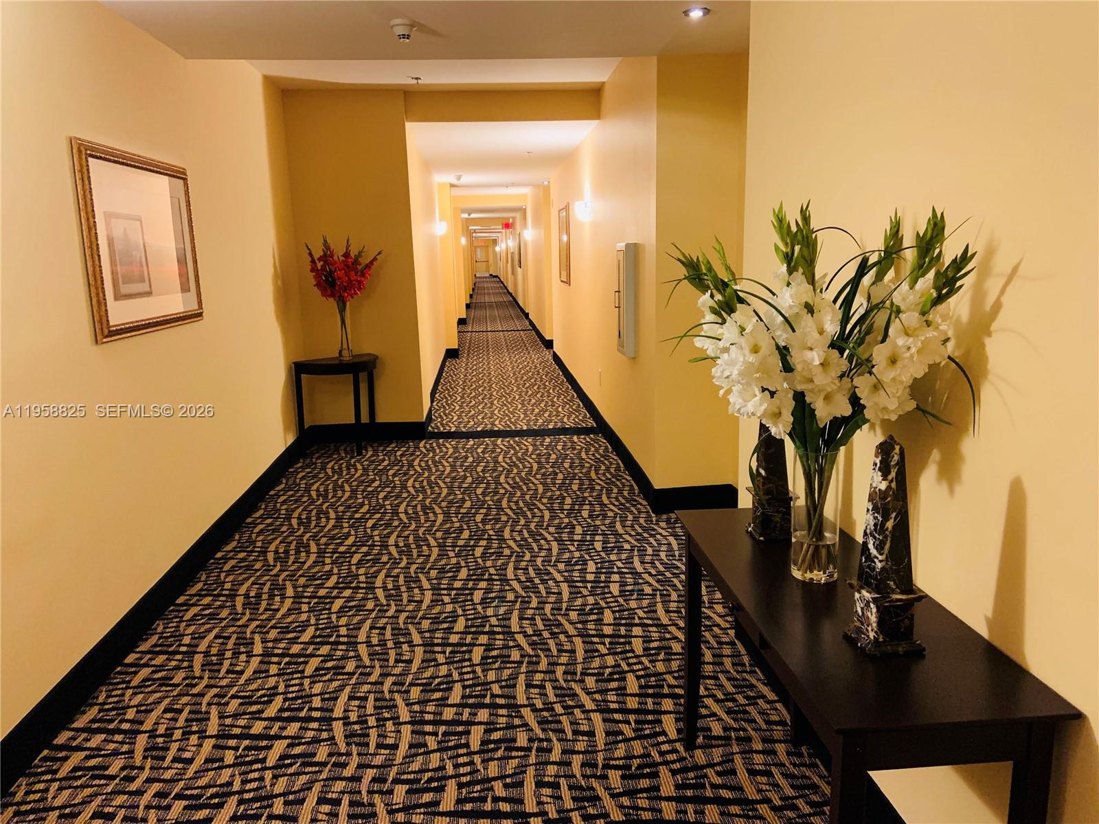 8395 Southwest 73rd Avenue, Unit 704 Miami, FL 33143 - Photo 46 of 47 a view of a hallway with wooden floor and a potted plant