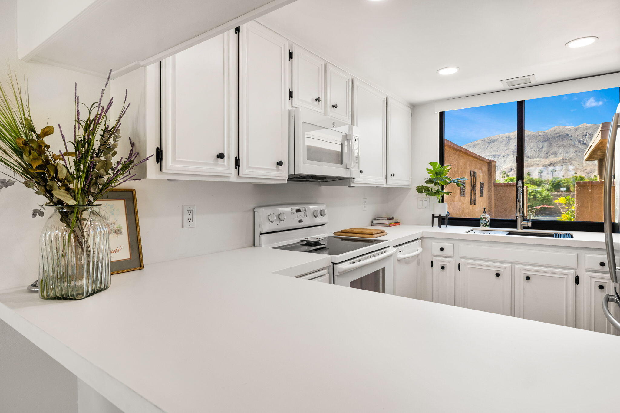56 Majorca Drive Rancho Mirage, CA 92270 - Photo 16 of 33 a kitchen with a white cabinets appliances and a window
