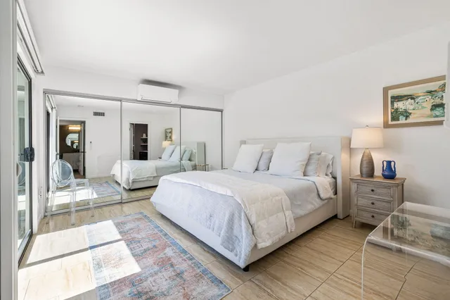 a bedroom with a bed and a large mirror