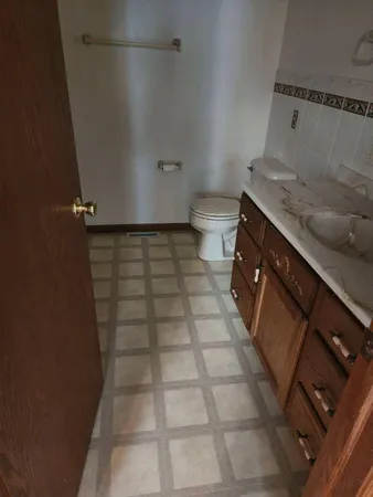 a bathroom with a granite countertop sink a toilet and a mirror