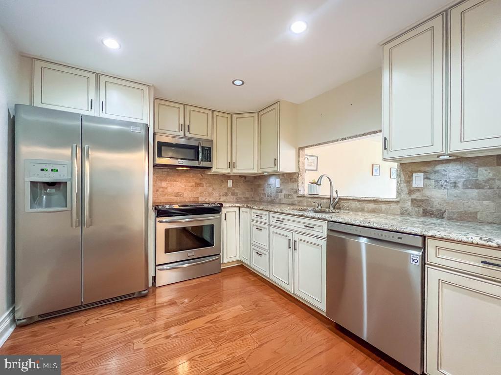 6204 Delaire Landing Road, Unit 204 Philadelphia, PA 19114 - Photo 10 of 40 a kitchen with granite countertop a refrigerator stove top oven and sink