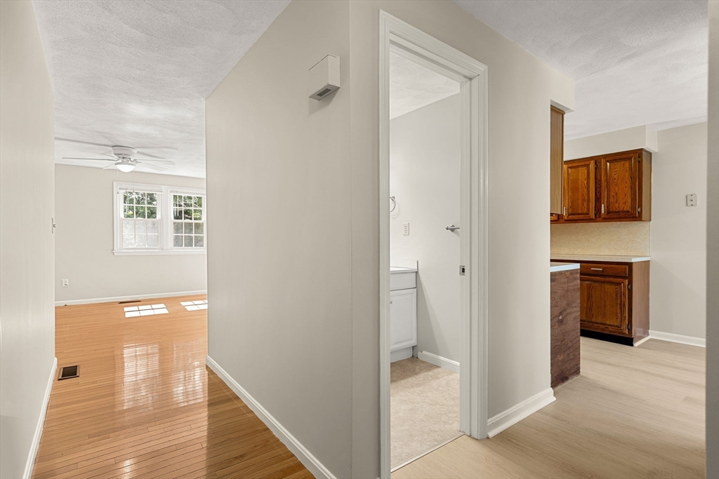 290 Apache Way, Unit 290 Tewksbury, MA 01876 - Photo 13 of 29 a view of a hallway with wooden floor and a bathroom