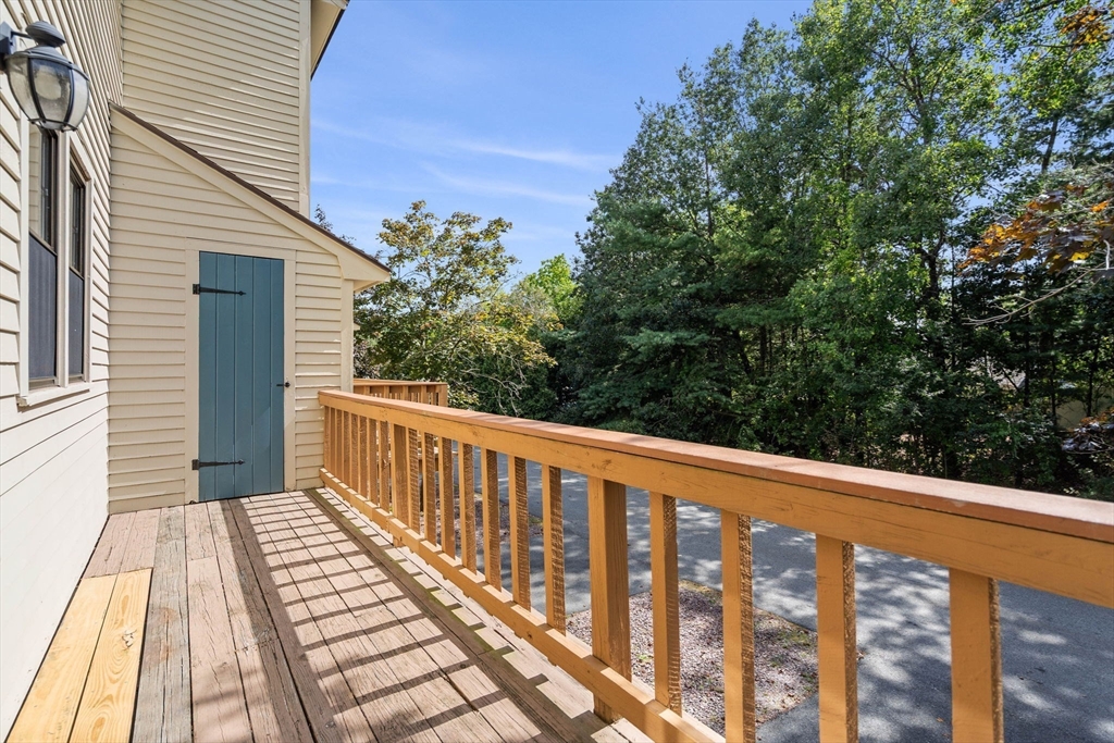 290 Apache Way, Unit 290 Tewksbury, MA 01876 - Photo 15 of 29 a balcony with wooden floor and fence