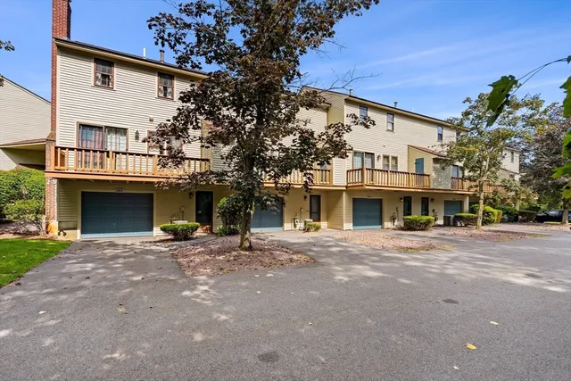 a front view of a house with yard and parking