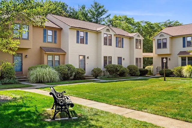 a view of a house with a yard chairs and table in patio