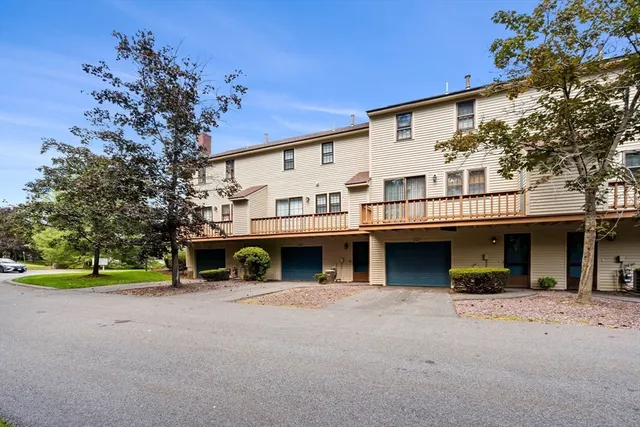 a view of a house with a yard and large tree