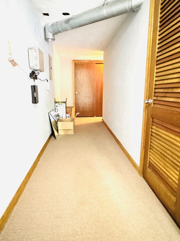 290 Apache Way, Unit 290 Tewksbury, MA 01876 - Photo 28 of 29 a hallway with a couch and chandelier