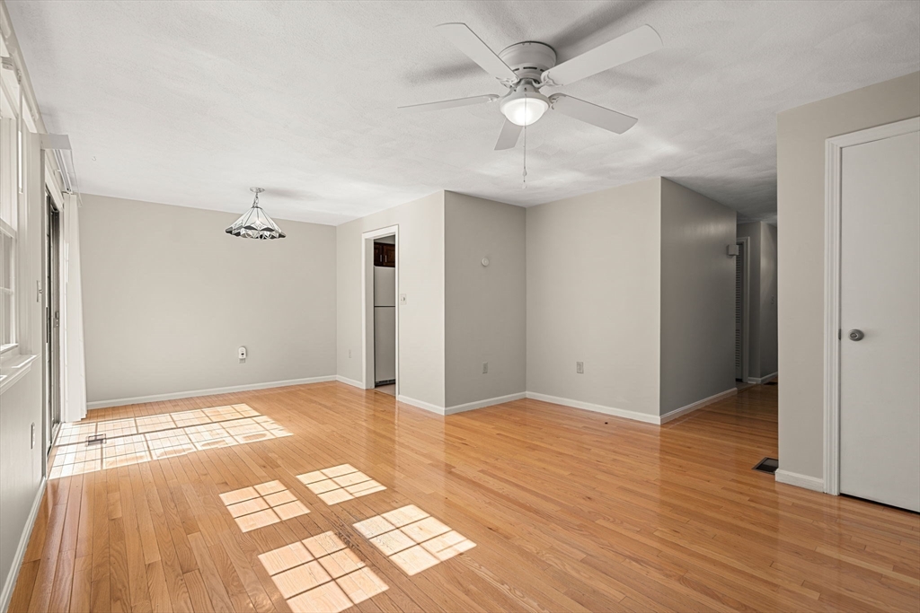 290 Apache Way, Unit 290 Tewksbury, MA 01876 - Photo 4 of 29 an empty room with wooden floor and window