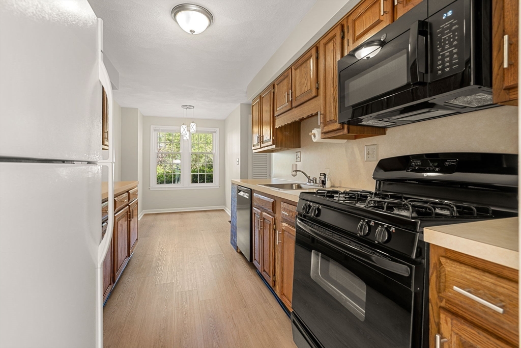 290 Apache Way, Unit 290 Tewksbury, MA 01876 - Photo 7 of 29 a kitchen with stainless steel appliances a stove a sink and a microwave