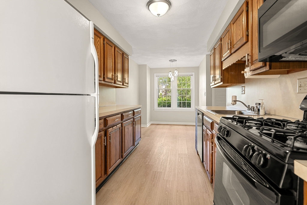290 Apache Way, Unit 290 Tewksbury, MA 01876 - Photo 8 of 29 a kitchen with stainless steel appliances a stove a sink and a refrigerator