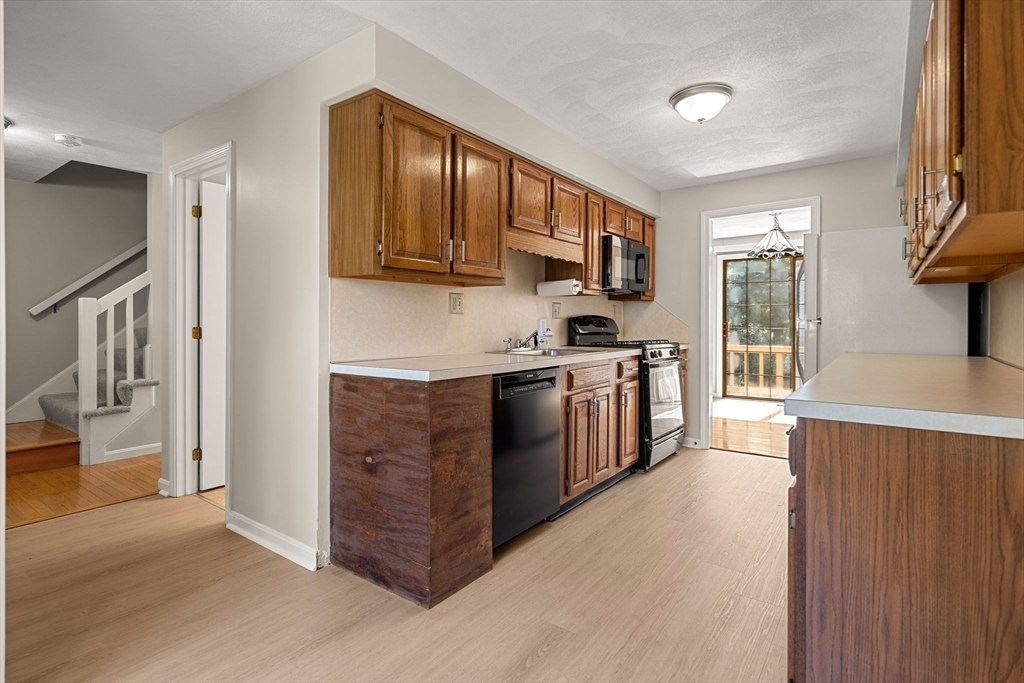 290 Apache Way, Unit 290 Tewksbury, MA 01876 - Photo 9 of 29 a kitchen with stainless steel appliances granite countertop a stove a sink and a refrigerator