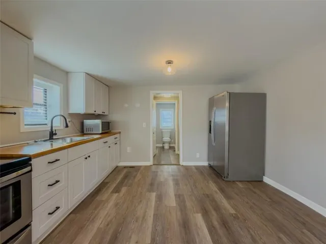 a kitchen with granite countertop a sink and wooden floor
