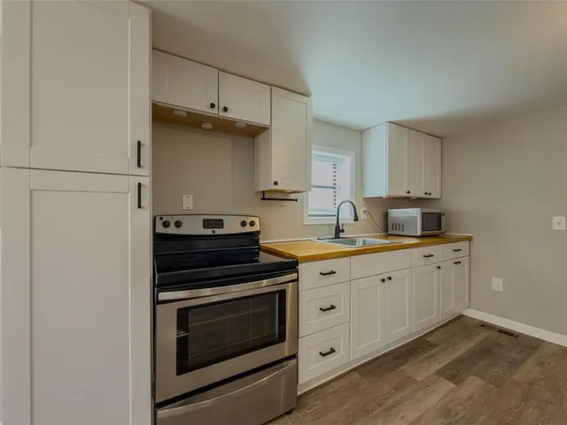 a kitchen with granite countertop cabinets stainless steel appliances and a sink