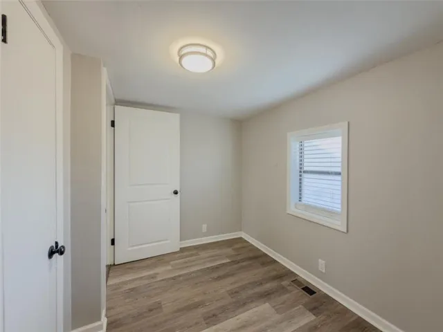 an empty room with wooden floor and window