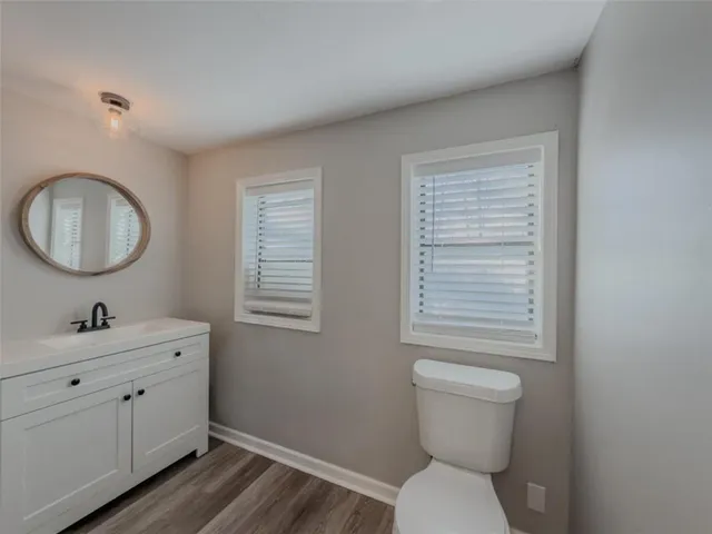 a bathroom with a toilet a sink and mirror