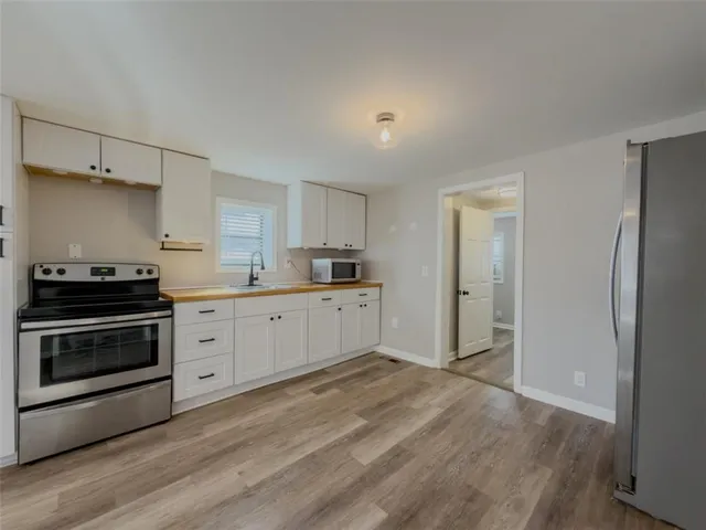 a kitchen with stainless steel appliances white cabinets and a refrigerator
