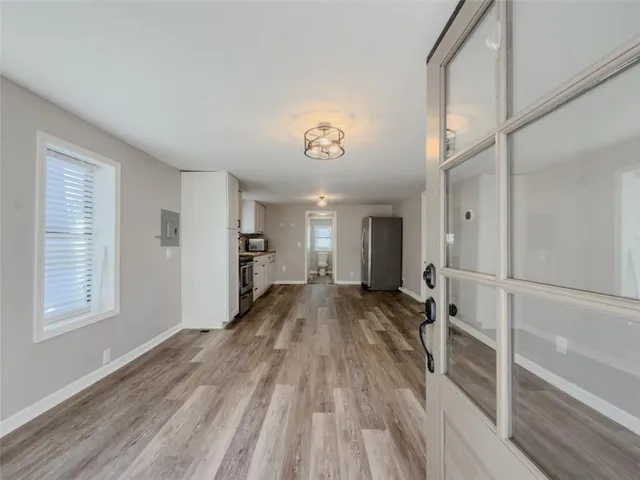 a view of a hallway with wooden floor and a living room