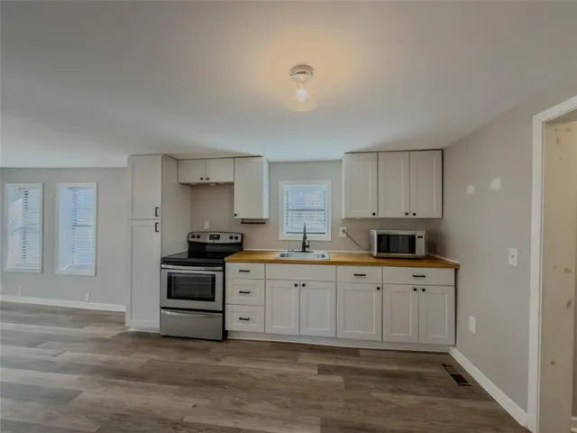 a kitchen with stainless steel appliances granite countertop a stove and white cabinets