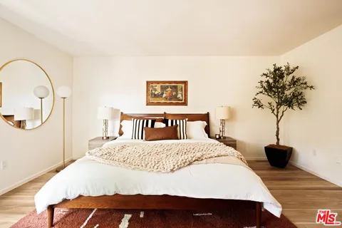 a bedroom with a bed and a potted plant