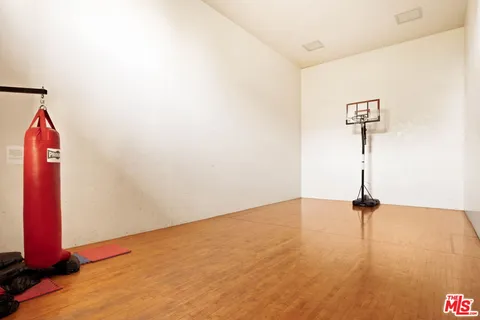 a view of a room with a wooden floor and a ceiling fan