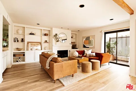 a living room with fireplace furniture and a large window