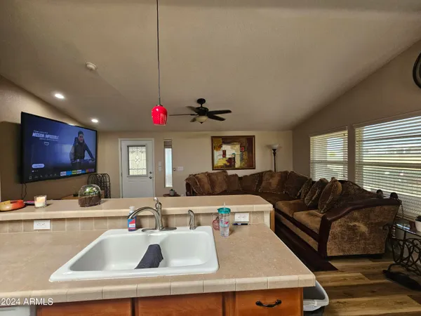 a living room with furniture a flat screen tv and kitchen view