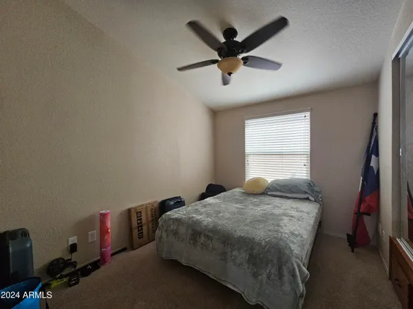 a bedroom with a bed and a chandelier fan