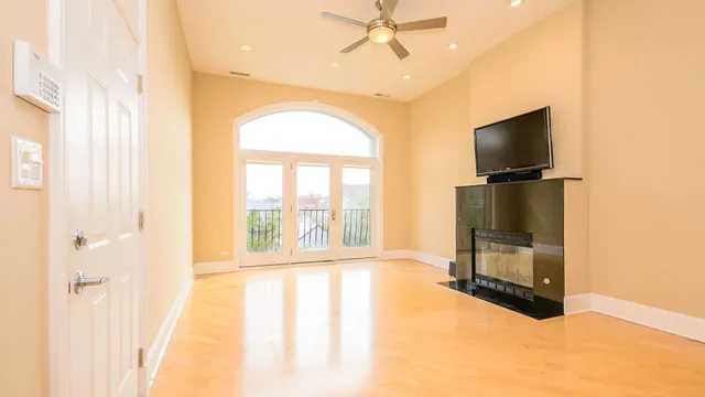 an empty room with a window and a ceiling fan