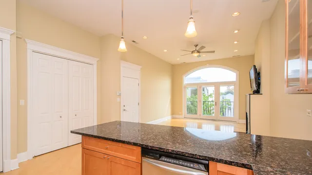 a kitchen with stainless steel appliances granite countertop a refrigerator a stove and a sink with wooden floor