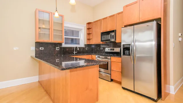 a kitchen with stainless steel appliances granite countertop a sink and a stove