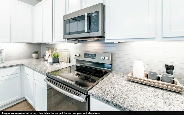 a kitchen with stainless steel appliances granite countertop a stove and a microwave
