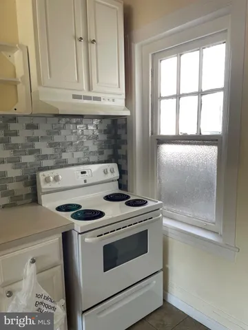 a stove top oven sitting inside of a kitchen