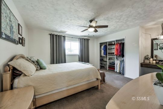 1233 Mayo Street Ridgecrest, CA 93555 - Photo 24 of 32 a bedroom with a bed dresser and a flat screen tv
